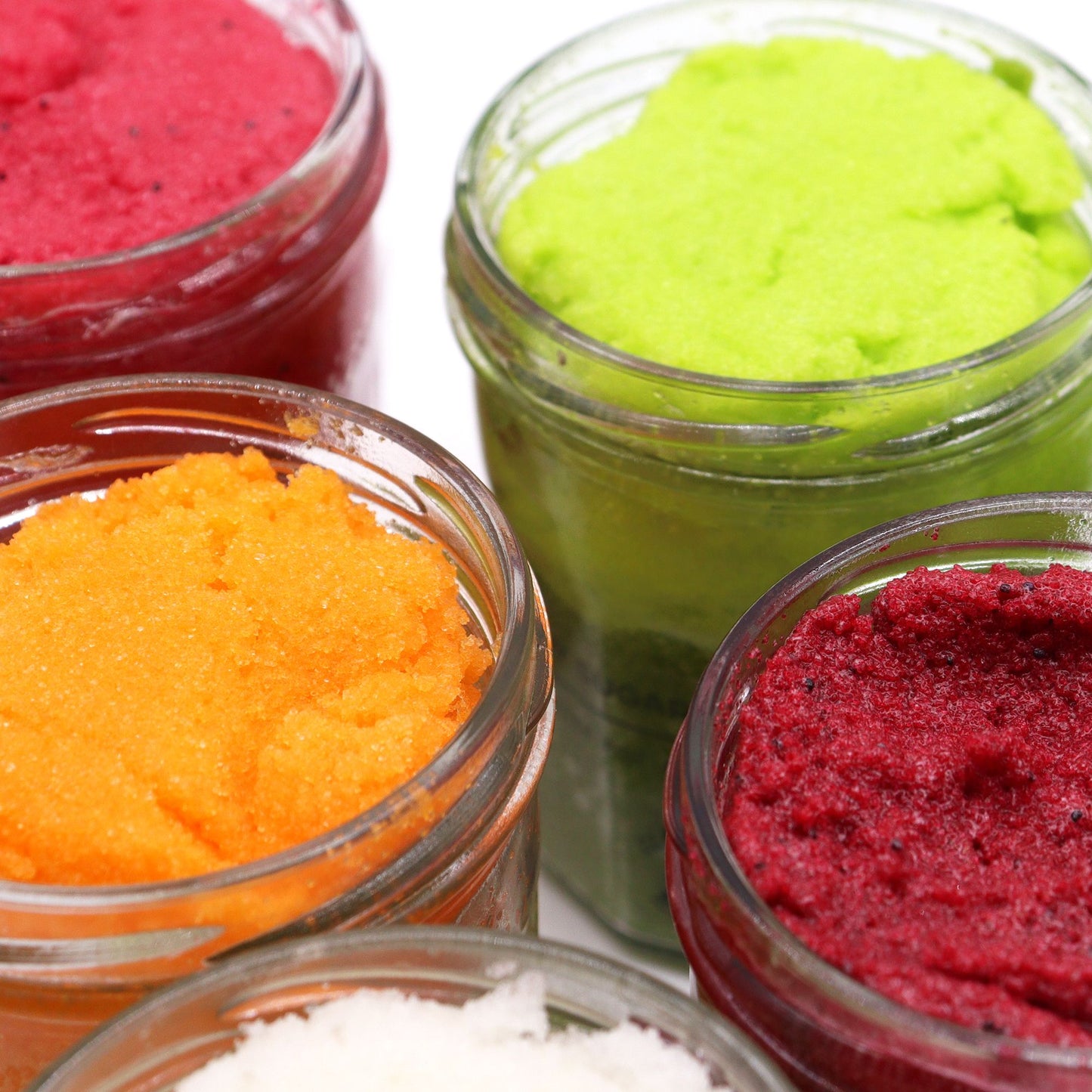 Fragranced sugar body scrub by The Bliss Co with watermelon daiquiri scent, featuring a jar with pink exfoliating sugar and fresh fruit slices