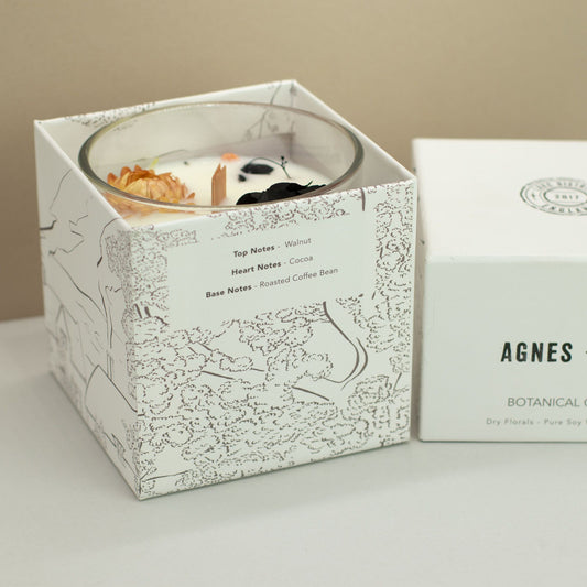 Agnes + Cat Botanical Soy Wax Candle by The Bliss Co in Lakeland Mocha, with a cozy mocha-colored candle on a wooden surface.