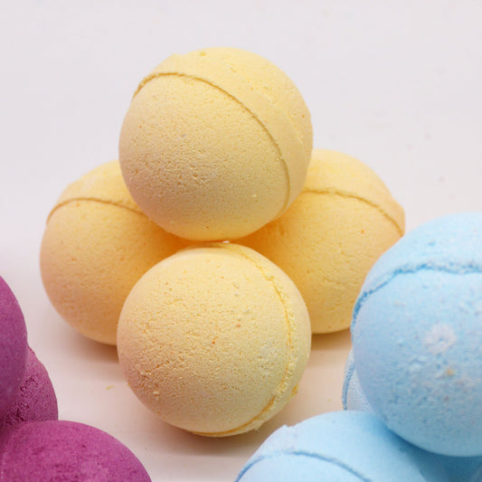 Essential Oil Bath Bomb with chamomile and grapefruit scents by The Bliss Co, showing a colorful bath bomb resting on a spa towel.