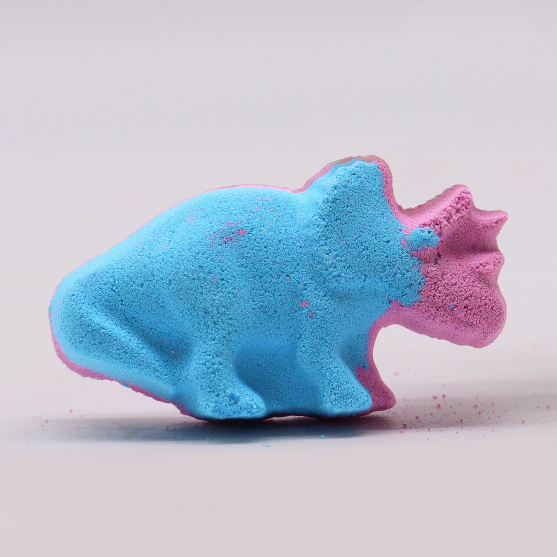Colorful Dinosaur-shaped bath bomb for kids, 80g by The Bliss Co, with vibrant swirls and playful design in a bathroom setting.