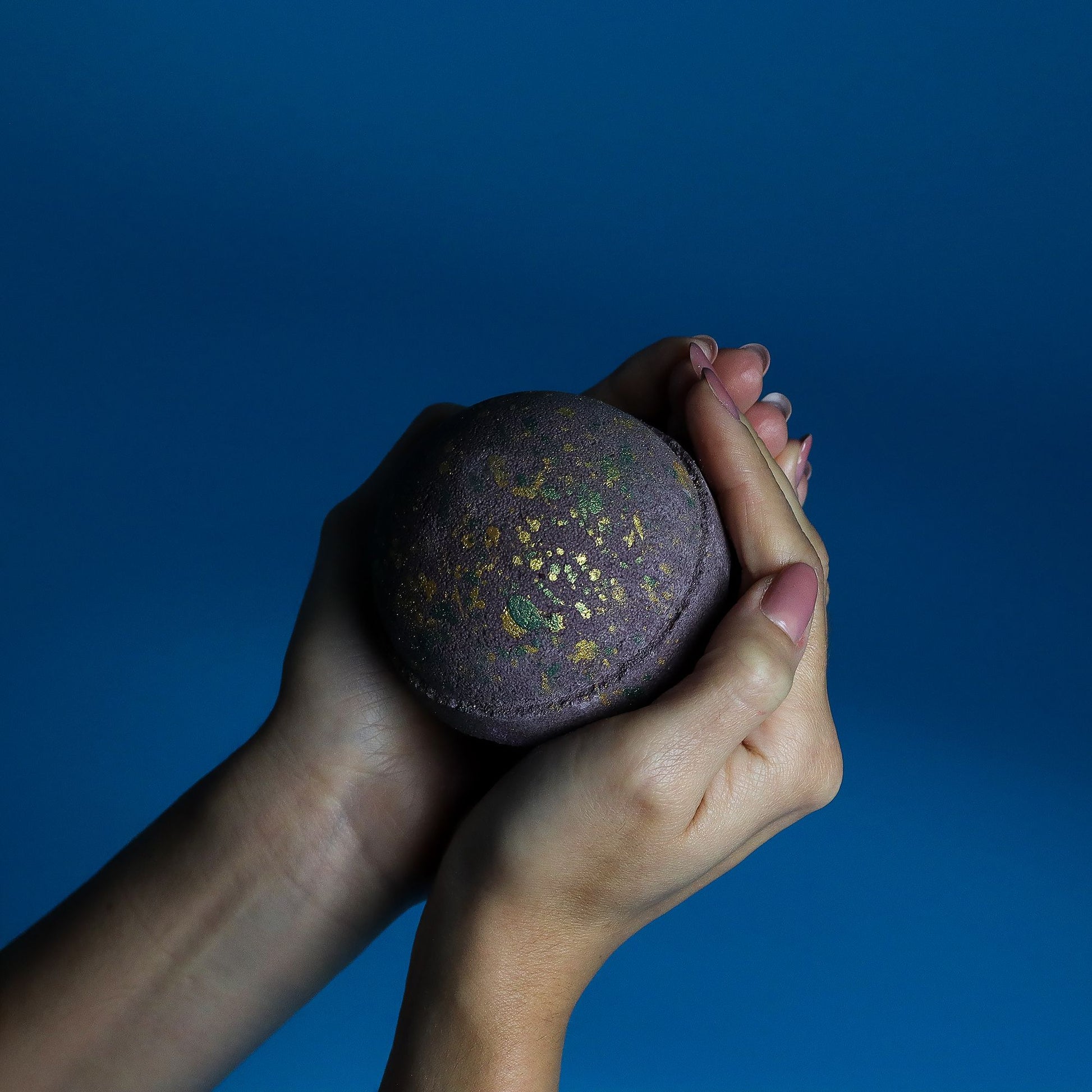 Jumbo Dubai Bath Bomb by The Bliss Co with emerald oudh and truffle scent, 180g, floating in a bath filled with colorful bubbles.