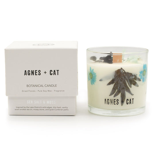 Agnes + Cat Botanical Soy Wax Candle by The Bliss Co with seasalt and moss scent, featuring a minimalist white candle in a clear glass jar.