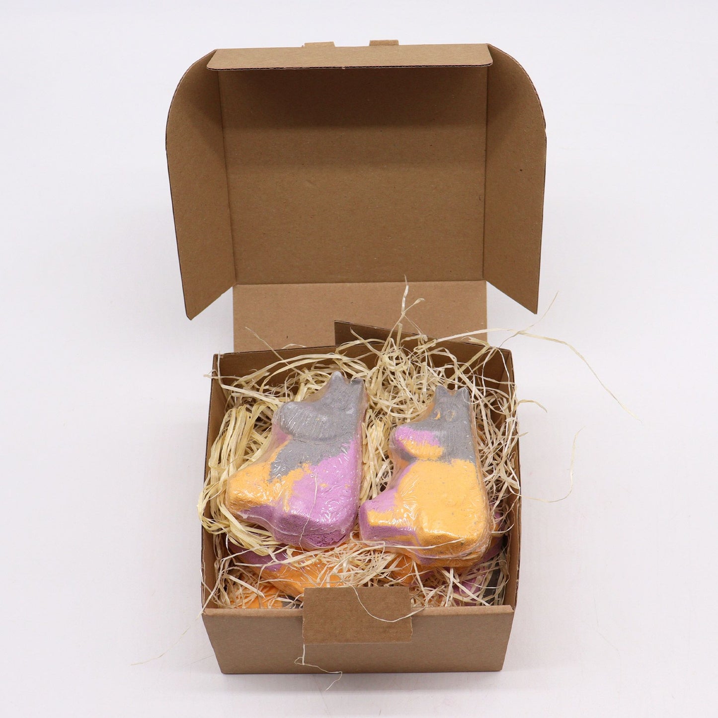 Colorful Hippo shaped bath bomb for kids by The Bliss Co, 85g, floating in water with vibrant bubbles.