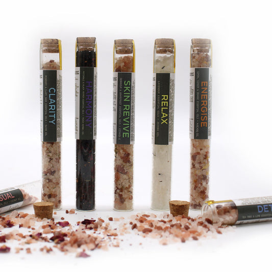 Set of 7 The Bliss Co bath salts in glass vials arranged in a gift pack, showcasing colorful salts and elegant packaging.