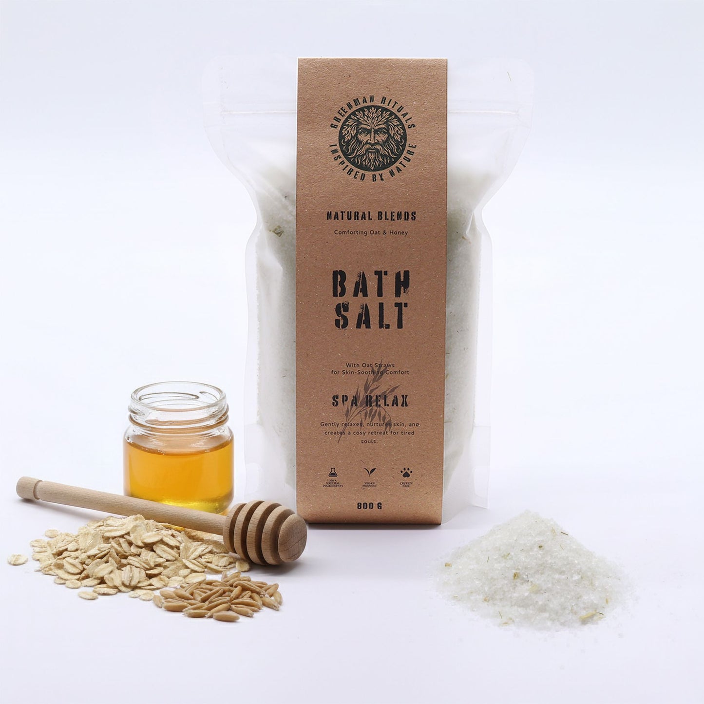 Greenman Rituals Oat and Honey Epsom Bath Salt from The Bliss Co in a glass jar with a wooden scoop, showing natural ingredients.